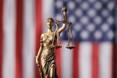 Bayan Adalet Amerikan bayrağının önünde