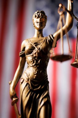 Bayan Adalet Amerikan bayrağının önünde