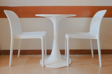 ahşap zemin ile boş bir odada beyaz sandalye.