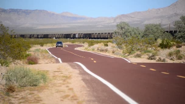 Пустынная дорога с грузовым поездом — стоковое видео