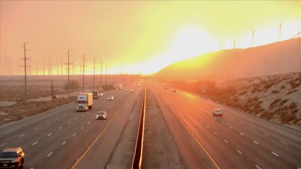 Αυτοκινητόδρομος στο ηλιοβασίλεμα με ανεμόμυλους — Αρχείο Βίντεο