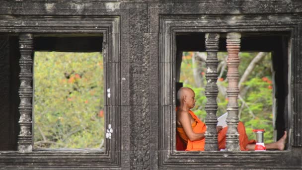 Monge budista meditando na janela do templo — Vídeo de Stock