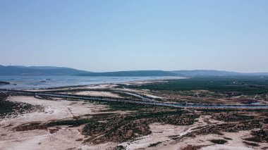 Hava aracı eski bir gölün yanından beyaz kumlar ve düz arkaplandan ateş ediyor. Mavi baskın renktir. Fotoğraf Bafa Gölü 'nde çekildi..