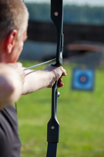 Man aiming bow at target — Stock Photo, Image