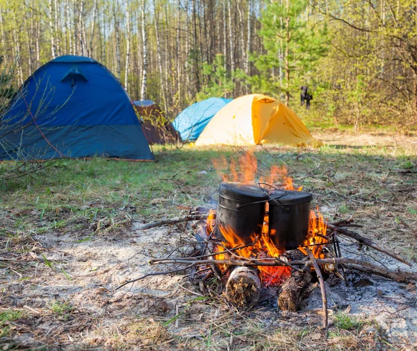 Cozinhar alimentos acampamento em caldeirões em fogo aberto — Fotografia de Stock