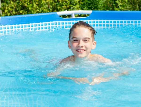 Счастливый ребенок плавает в бассейне на открытом воздухе — стоковое фото