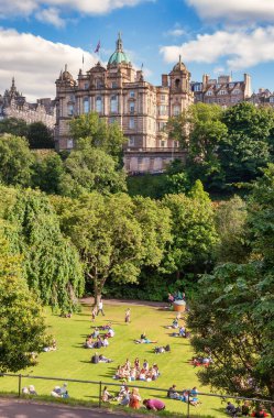 Edinburgh, İngiltere - 9 Ağustos 2012: Yerel halk ve turistler, şehir merkezindeki ünlü bir halk parkı olan Princes Street Gardens 'da güneşli sıcak yaz gününün tadını çıkarıyorlar.