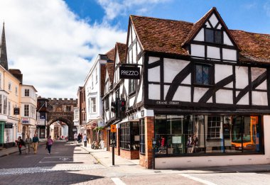 Salisbury, İngiltere - 9 Haziran 2013: High Street boyunca yürüyen turistler. Arka planda Katedral 'e açılan Kuzey Kapısı görülüyor.