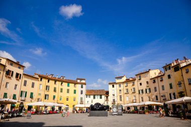 LUCCA, İtalya - 31 Mayıs 2018: Piazza dell Anfiteatro 'da turistler, eski Roma amfitiyatrosunun şeklinden sonra Lucca' nın en güzel meydanlarından biridir.