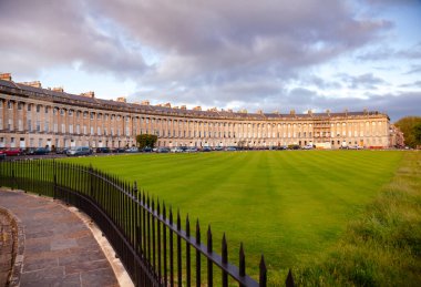 BATH, İngiltere - 11 Haziran 2013: Gürcistan mimarisinin en büyük örneklerinden biri olan geniş bir hilal içinde 30 teraslı ev sırasına dizilmiş Royal Crescent manzarası