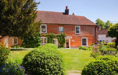 CHAWTON, İngiltere - 8 Haziran 2013: Chawton Cottage 'ın resmi bahçesinde yeşil çimen, bağımsız bir roman yazarı Jane Austen müzesi