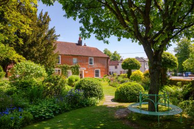 CHAWTON, İngiltere - 8 Haziran 2013: Bağımsız romancı Jane Austen müzesi Chawton Cottage 'ın resmi bahçesinde yuvarlak bank