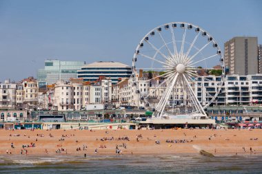 BRIGHTON, İngiltere - 5 HAZİRAN 2013: Güneşli bir yaz gününde Ferris Wheel yakınlarındaki tavernada güzel havanın tadını çıkaran tatilciler