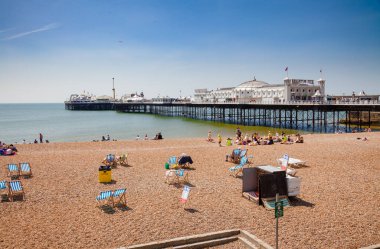 BRIGHTON, İngiltere - 5 Haziran 2013: Brighton Palace Rıhtımı yakınlarındaki bir tavernada yaz havasının tadını çıkaran tatilciler