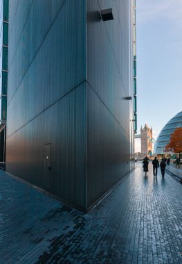 LONDON, UK - NOV 1, 2012: Bir sabah içinde Londra Riverside üzerinden Londra Belediye Binasına yürüyen yayalar. Kule Köprüsü arkaplanda görünüyor
