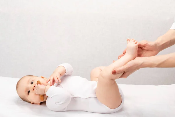 在儿科诊所接受按摩治疗的6个月女婴很开心 手工操作儿童的脚 — 图库照片