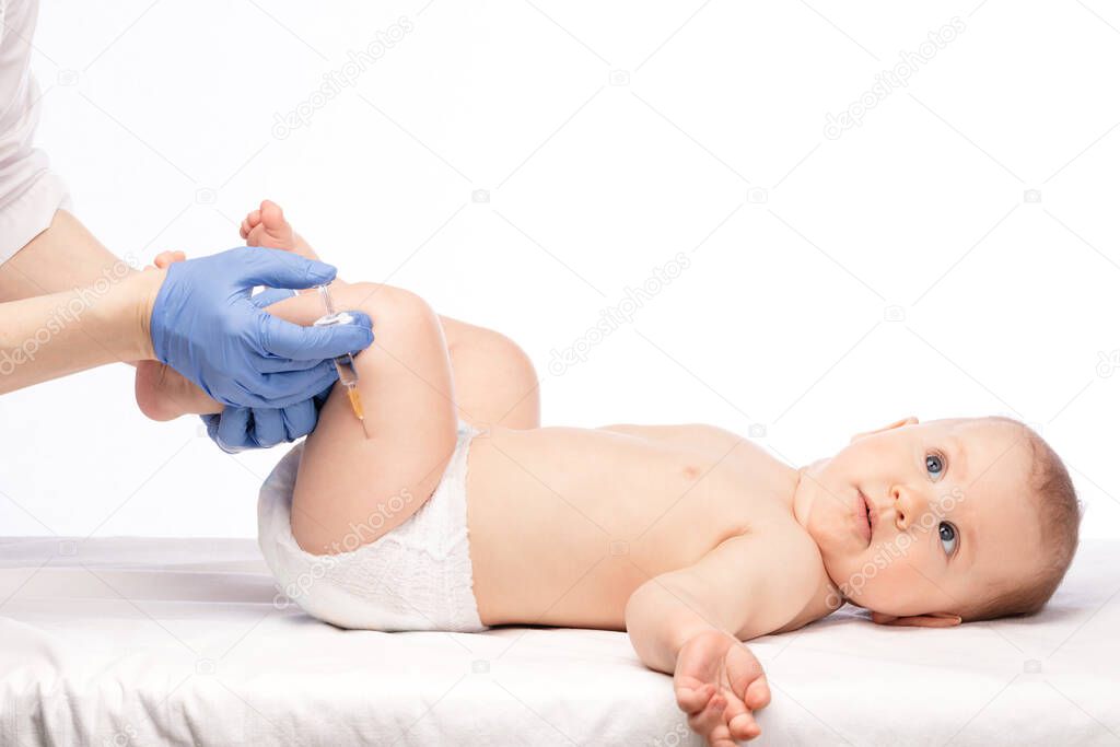Pediatrician or nurse giving an intramuscular injection of a vaccine to leg of baby girl during coronavirus COVID-19 pandemic
