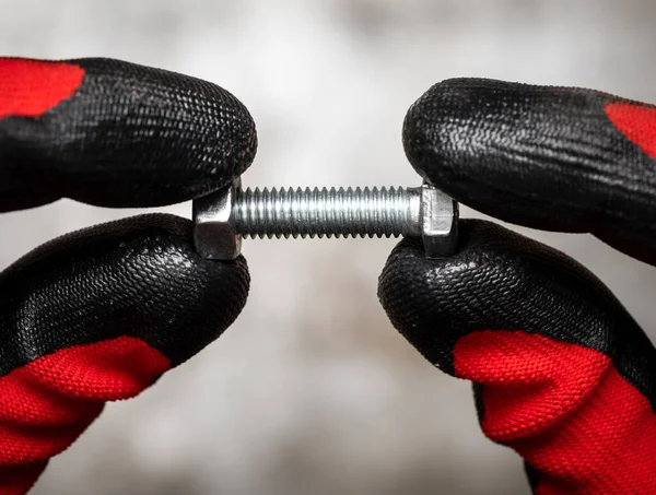 Persoon Met Beschermende Handschoenen Met Bout Moer Tegen Metalen Achtergrond — Stockfoto