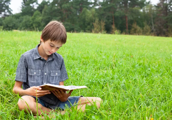 お子様は屋外の本を読んで — ストック写真