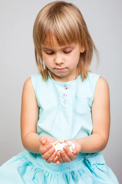 Kind hält Tabletten in gestülpten Händen — Stockfoto