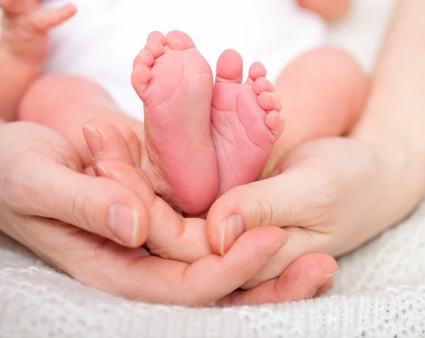 Holding bebeğin ayakları anne — Stok fotoğraf