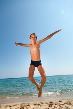 Çocuk plajda zıplıyor
