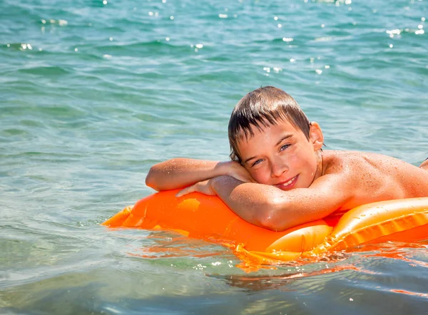 Boy on a inflatable mattress — Stock Photo, Image