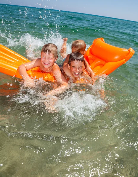 Children playing on a inflatable mattress — Stock Photo, Image