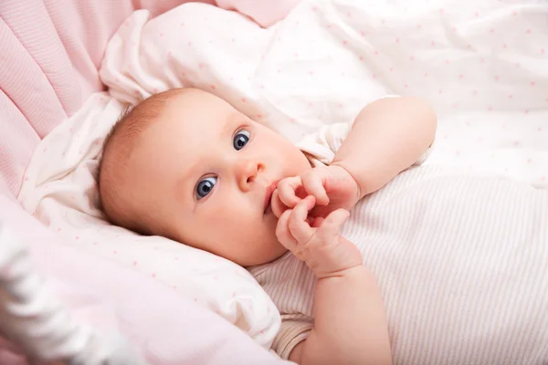 Meisje van de baby te leggen in een bassinett — Stockfoto