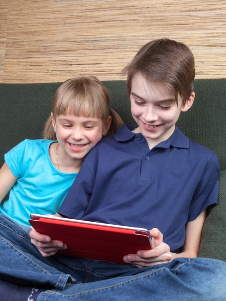 Siblings using a tablet computer — Stockfoto