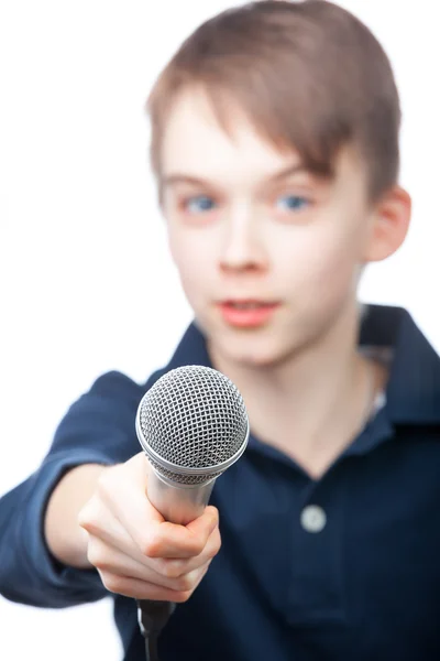 Pojken håller en mikrofon — Stockfoto