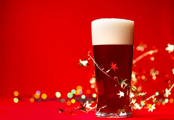 クマや赤の背景に見掛け倒しのクリスマス ライトのビールの一杯 — ストック写真