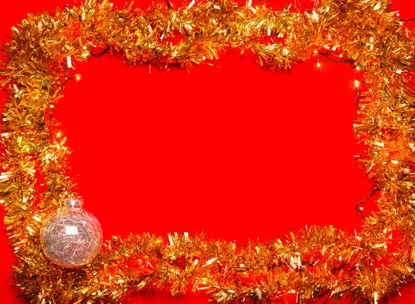 Kerstballen met verlichting en klatergoud frame op rode achtergrond — Stockfoto
