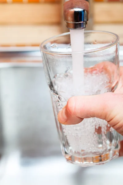 Riempire un bicchiere d'acqua dal rubinetto della cucina — Foto Stock