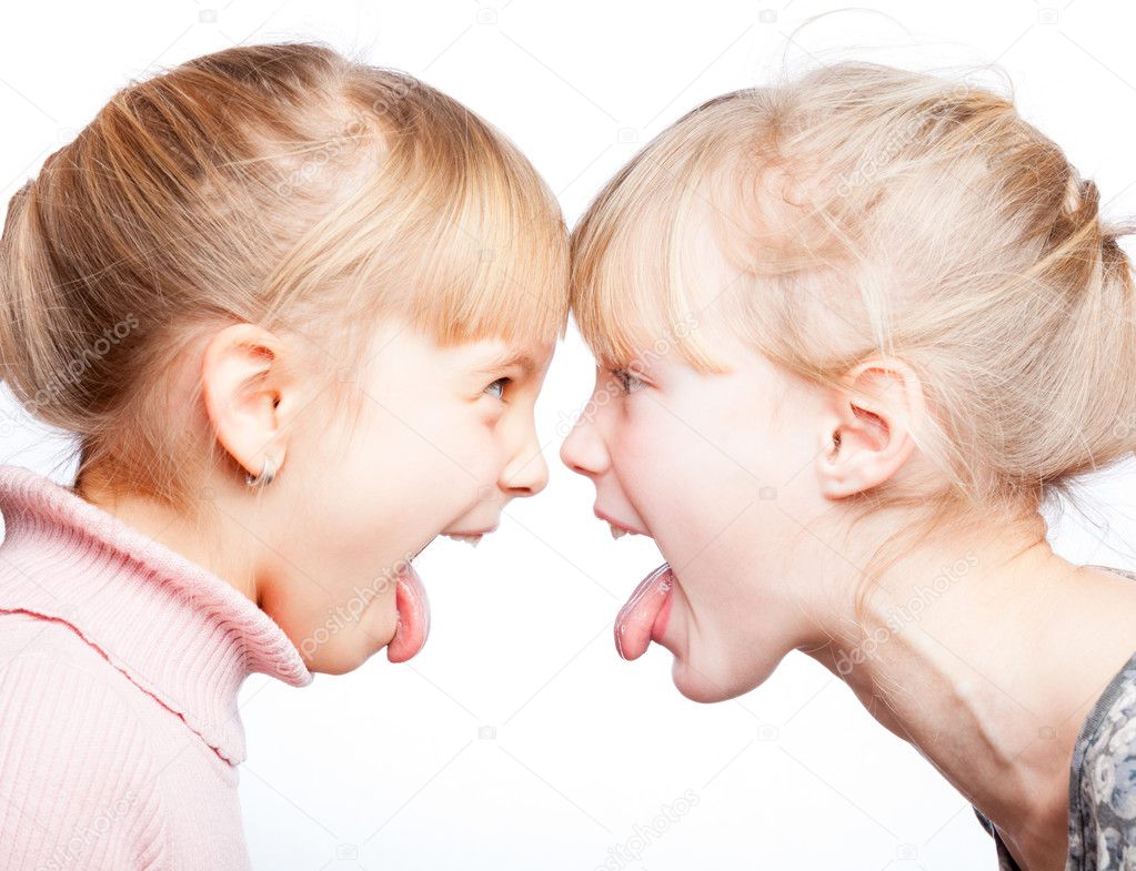 Children sticking out tongues head to head