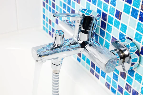 Bathtub tap on a blue tiled wall — Stock Photo, Image