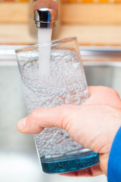Наполнение стакана водой из кухонного крана POV — стоковое фото