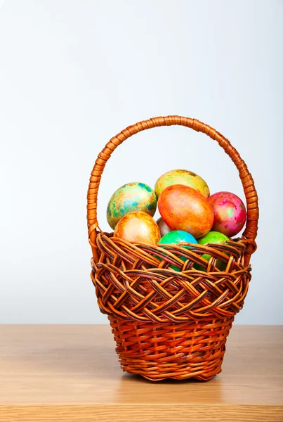 Colored easter eggs in basket — Stock Photo, Image