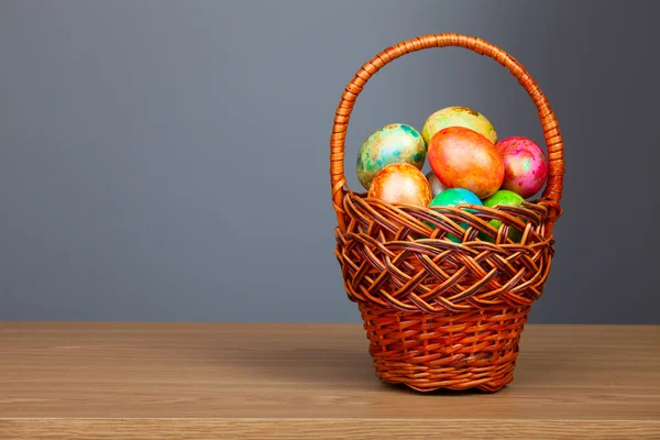 Colored easter eggs in basket — Stock Photo, Image