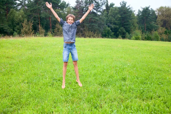 Niño saltando en el prado —  Fotos de Stock