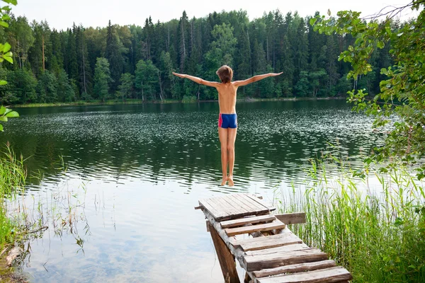 Niño saltando en el lago del bosque — Foto de Stock