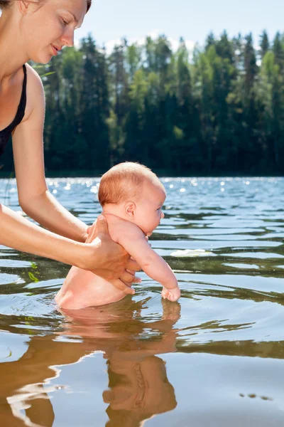 Mère baigne bébé en plein air — Photo