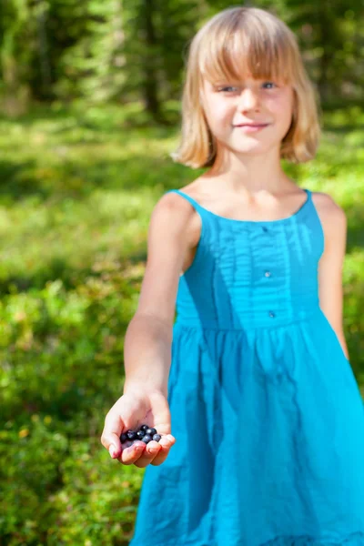 Girl shows picked berries in a summer forest shallow focus — Stock Photo, Image