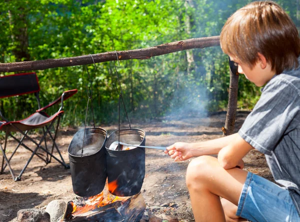 Kind kocht am Lagerfeuer — Stockfoto