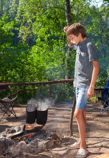 Child cooking on campfire — Stock Photo, Image