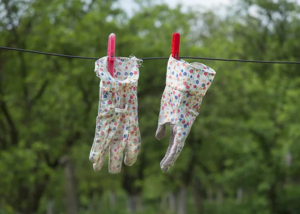 Gartenhandschuhe auf Draht mit verschwommenem grünen Hintergrund — Stockfoto