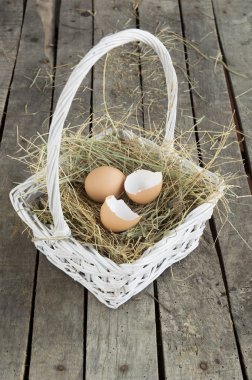 kırık yumurta kabuğu üzerinde saman beyaz sepet içinde ve yumurta