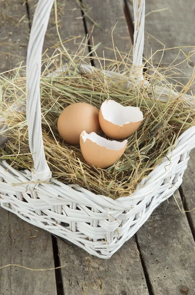 Primo piano di uovo e guscio d'uovo rotto nel cestino bianco — Foto Stock