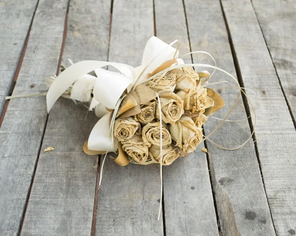 Bouquet of dried yellow roses on gray wooden table — Stock Photo, Image