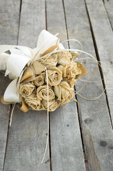 Bouquet of dried yellow roses on gray wooden background — Stock Photo, Image